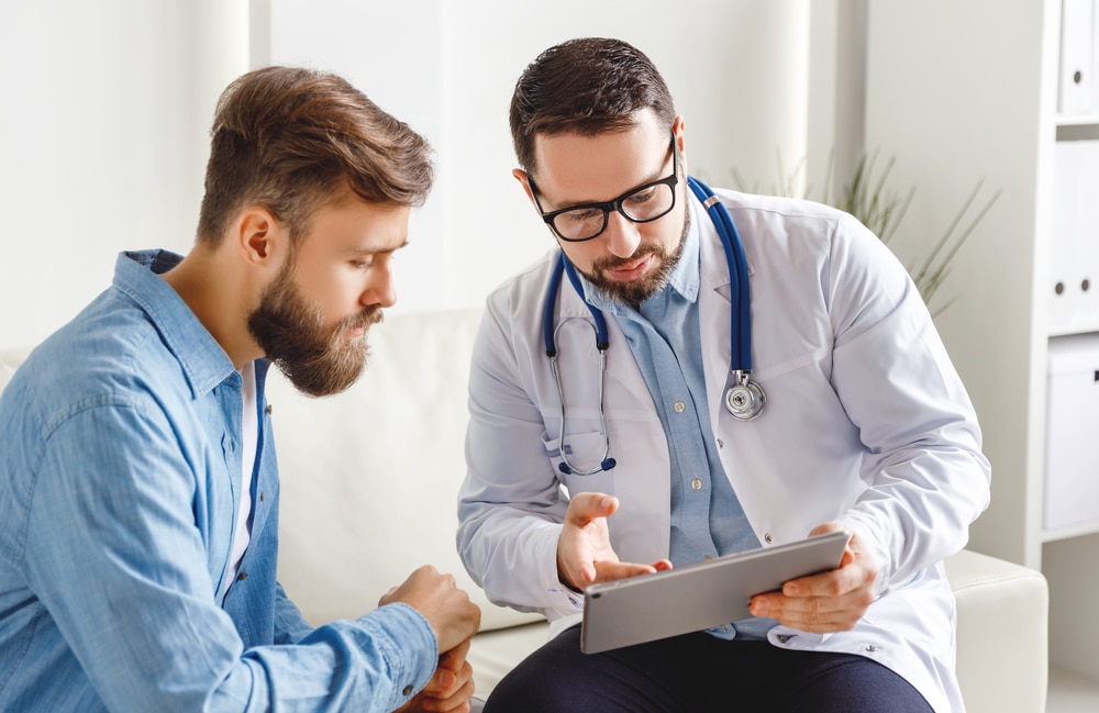 A doctor talking to a man about performing a testicular self-exam.